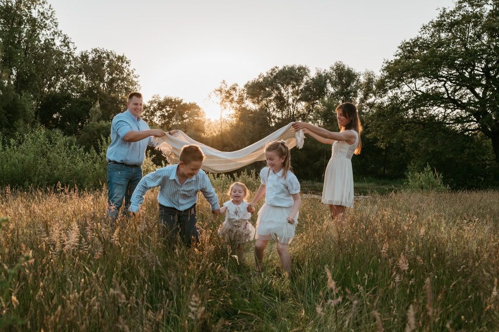 Melissa Stuer Photography Moederschapsfotograaf Moerbeke Oost-Vlaanderen lifestyle gezin  bij golden hour buiten zonsondergang natuur speels