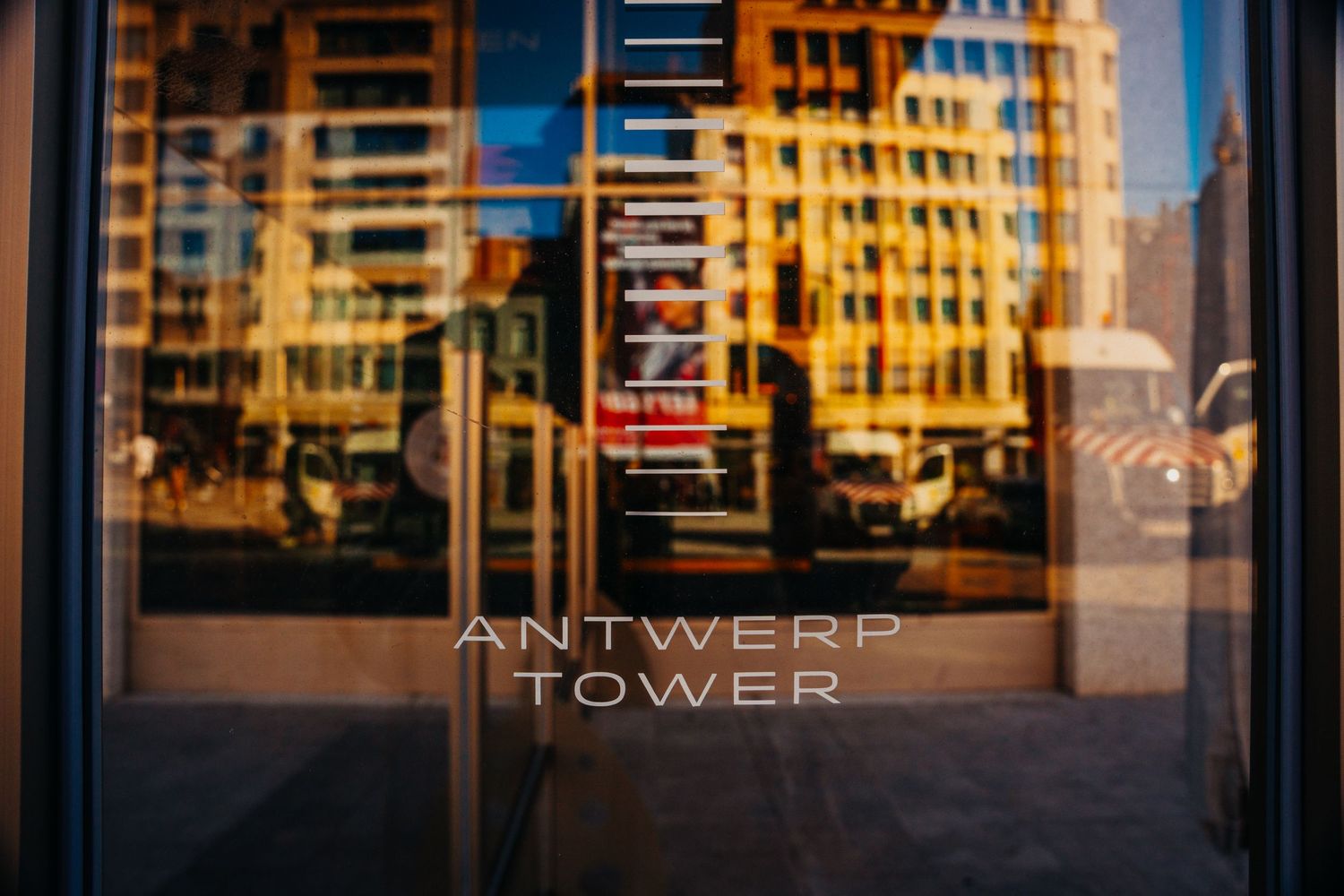 Reflectie van een glazen raam met de tekst Antwerp Tower.