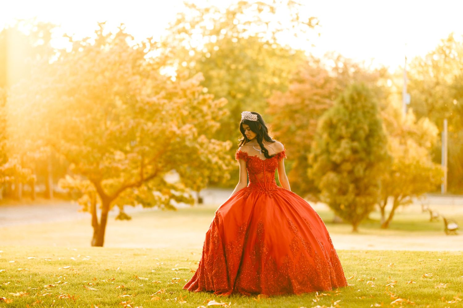 A girl in her red quinceañera dress pose outside of Woodward Park in Tulsa, Oklahoma.