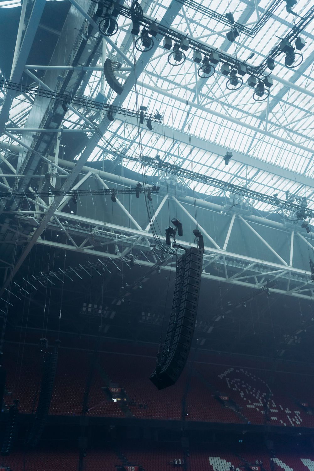 Professional stage rigging and lighting equipment mounted on glass ceiling structure.
