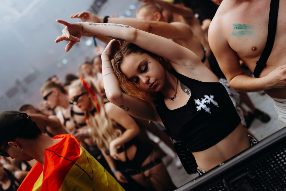 Dancing crowd enjoying electronic music at an indoor festival.