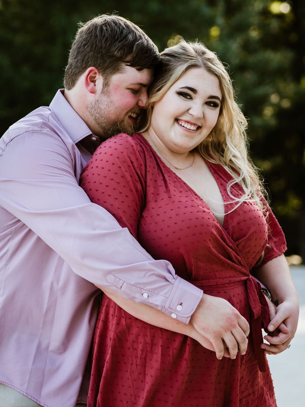 A tender moment between a couple wearing coordinating pink and red outfits.