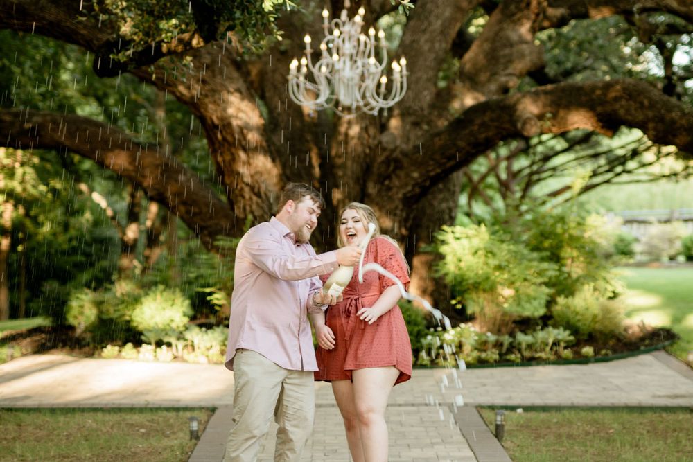 Couple dancing together under a grand tree with hanging crystal chandelier.