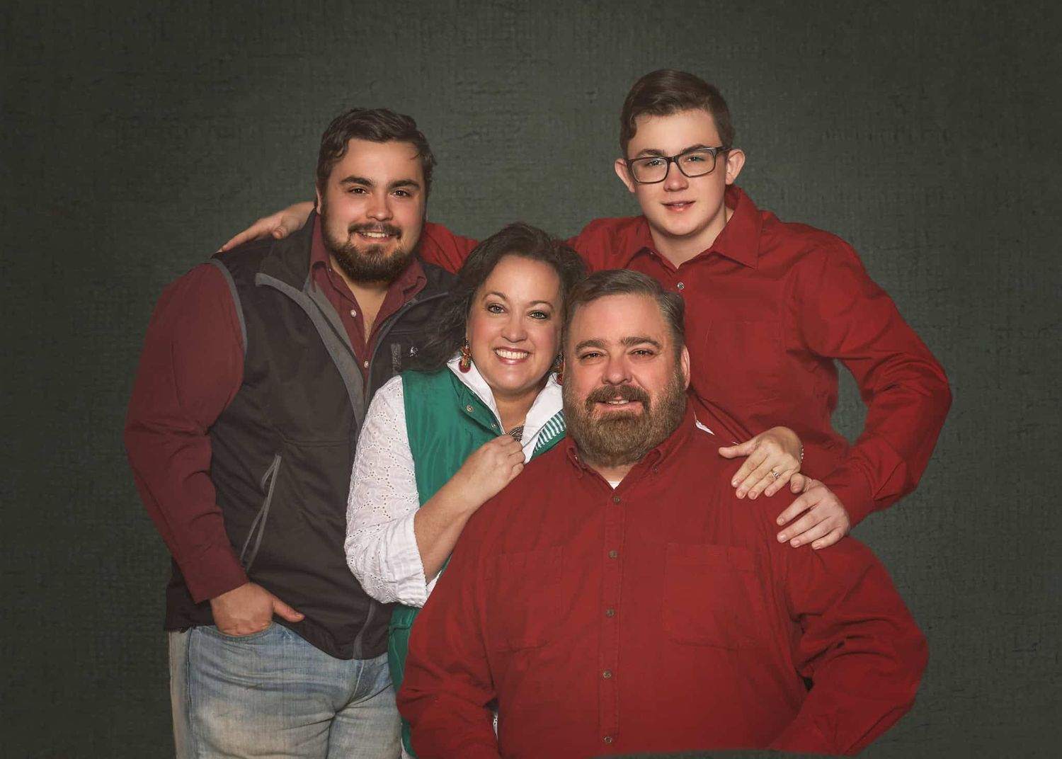 Middle-aged parents with three teenage and older sons in Christmas red shirts