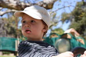 A young kid at a playground at a birthday party.