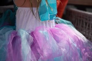 Close-up of a colorful tulle tutu skirt in shades of pink, purple and turquoise  at a birthday party.