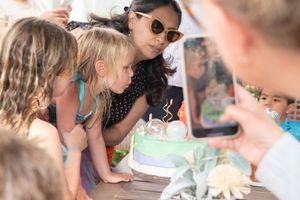 A child blows her birthday candles during her birthday celebration.