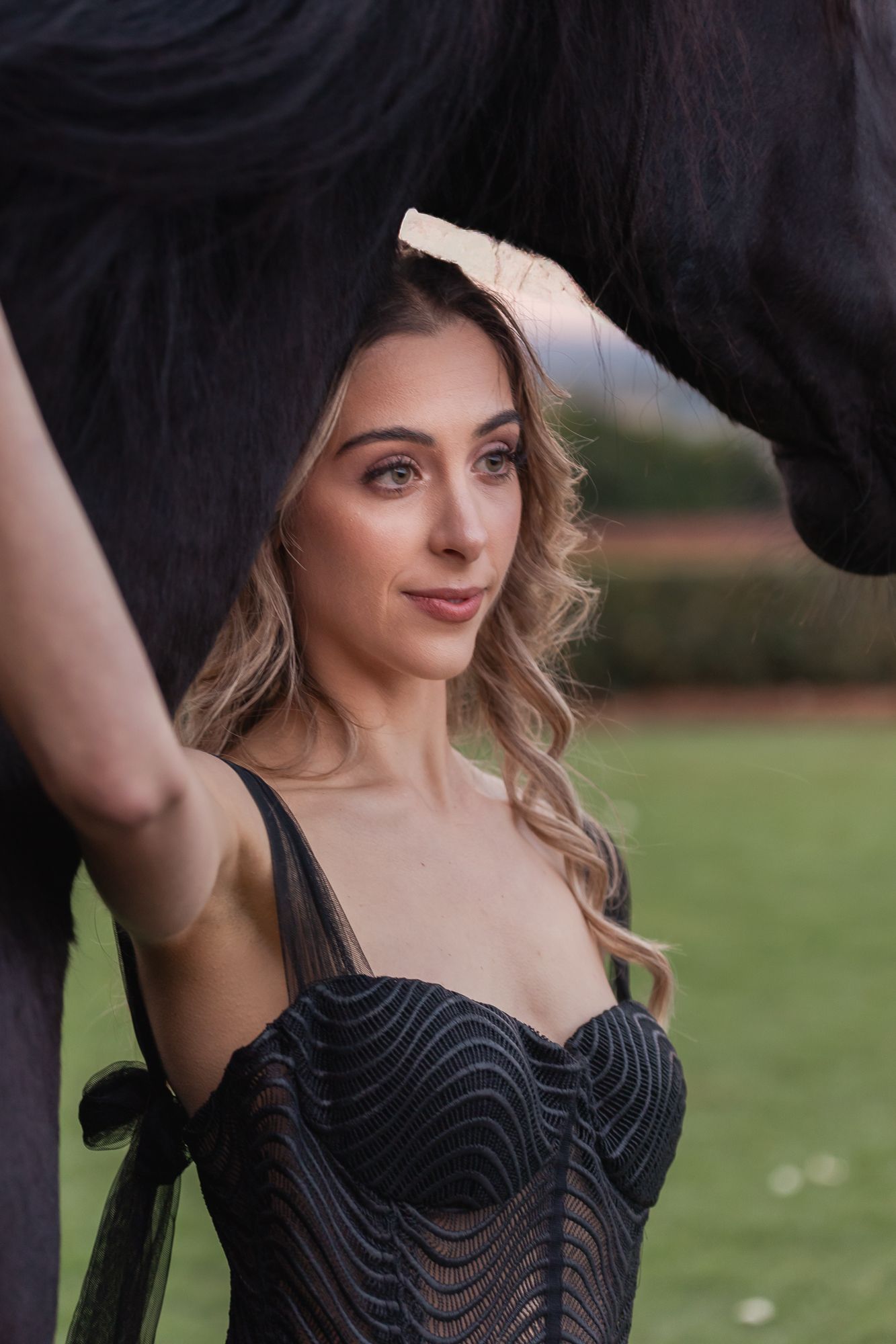 Elegant portrait series showing close interactions between a person in black and a dark horse.