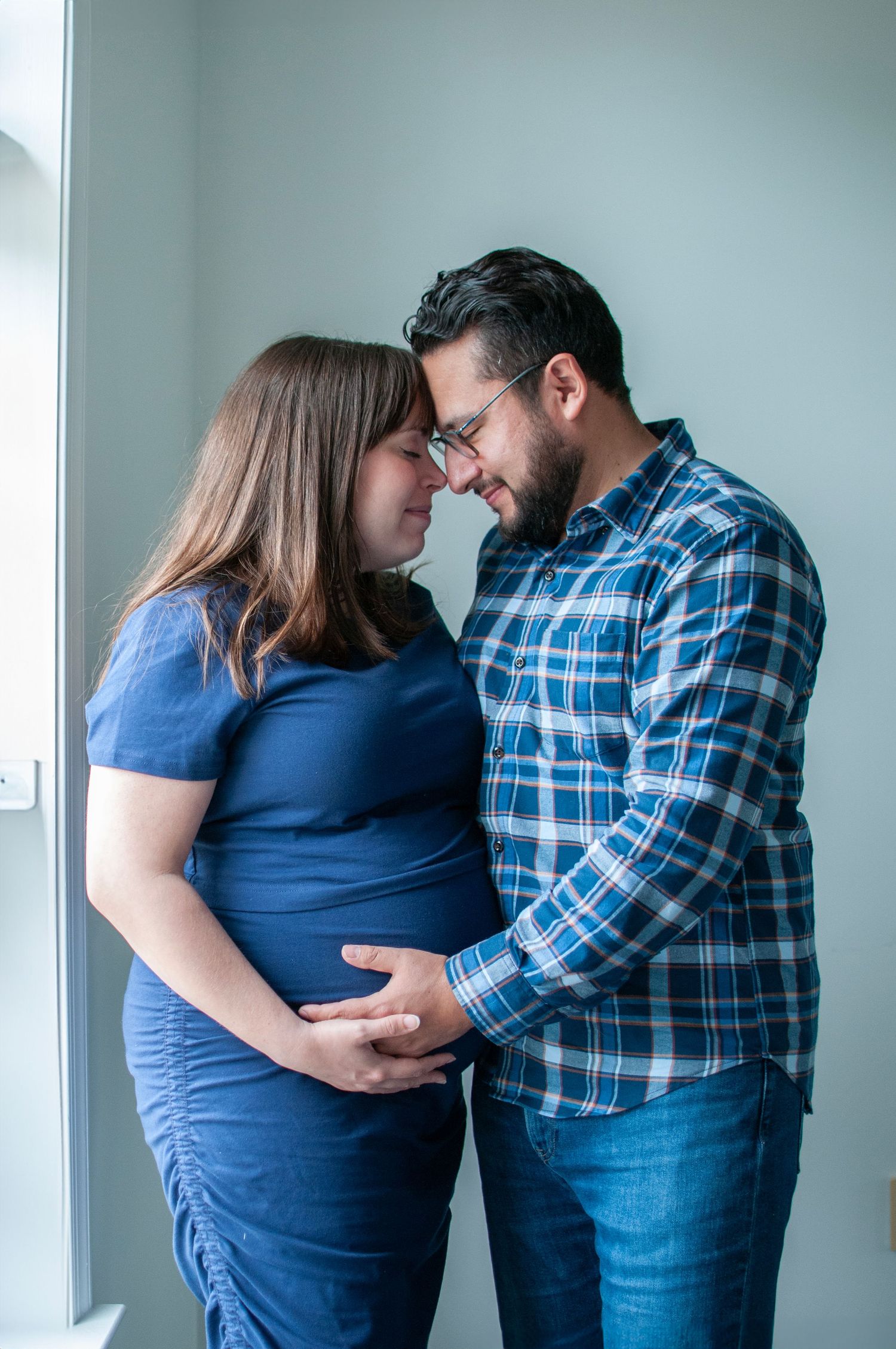 Couple with heads together maternity image indoor