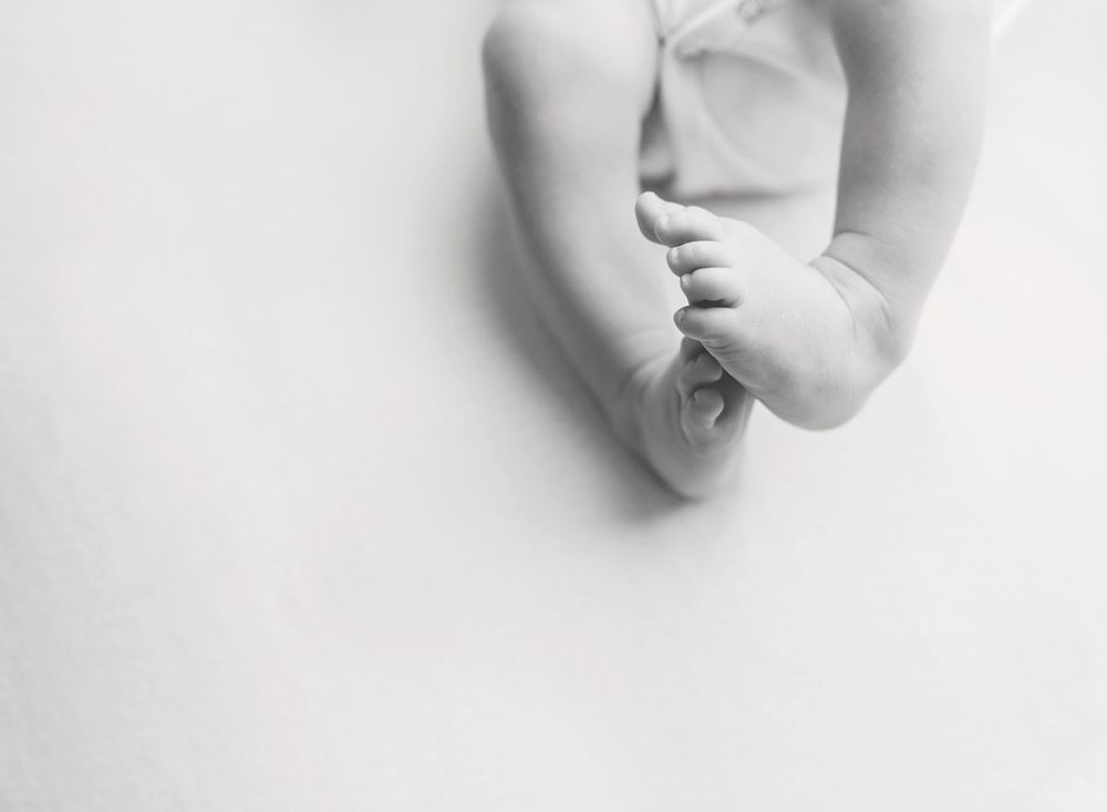 black and white image of newborn baby feet