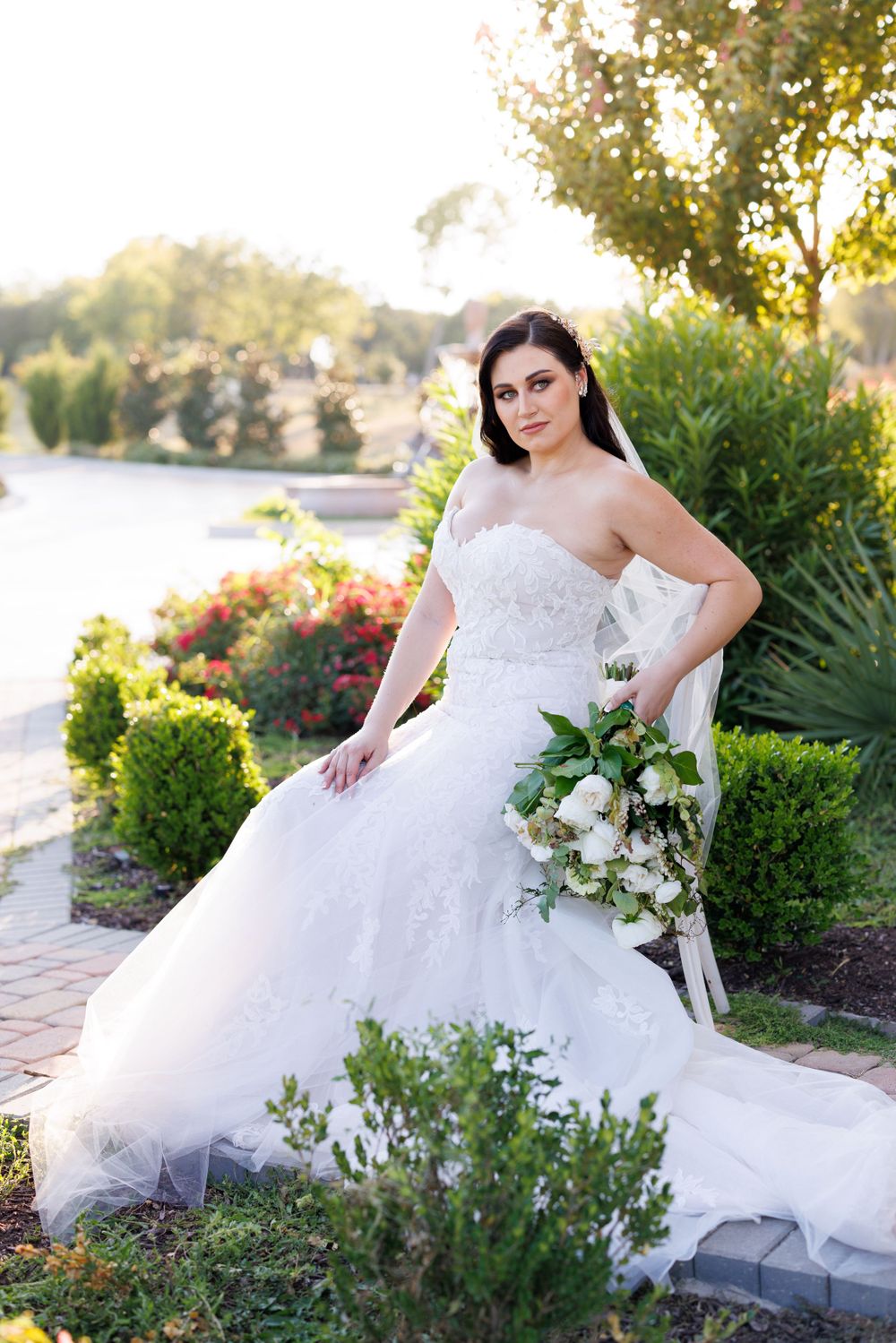 Bridal portraits in lush garden setting with white bouquet and full ballgown style dress.