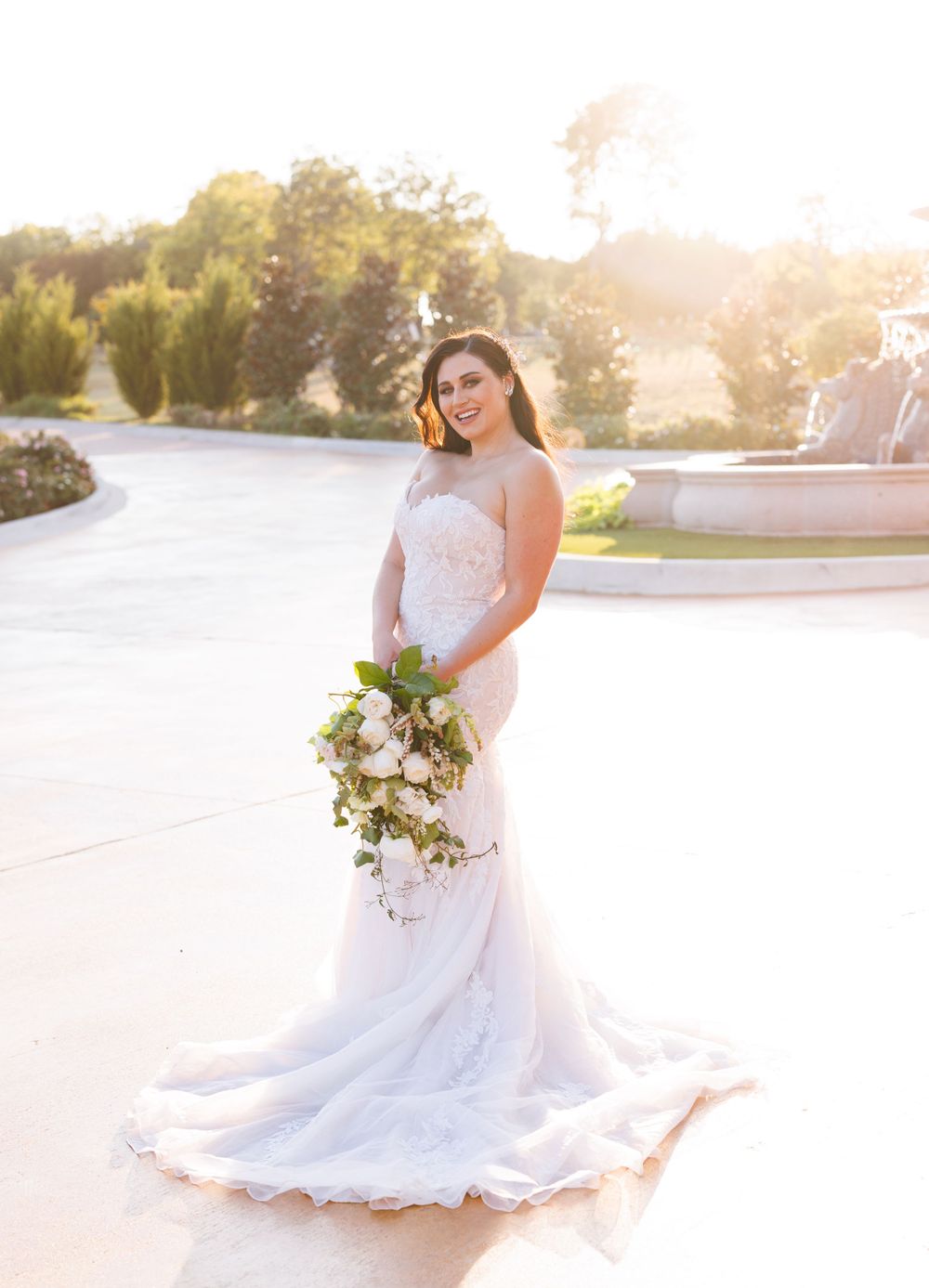 Sun-drenched bridal portraits showcasing flowing wedding gown and bouquet in outdoor setting.