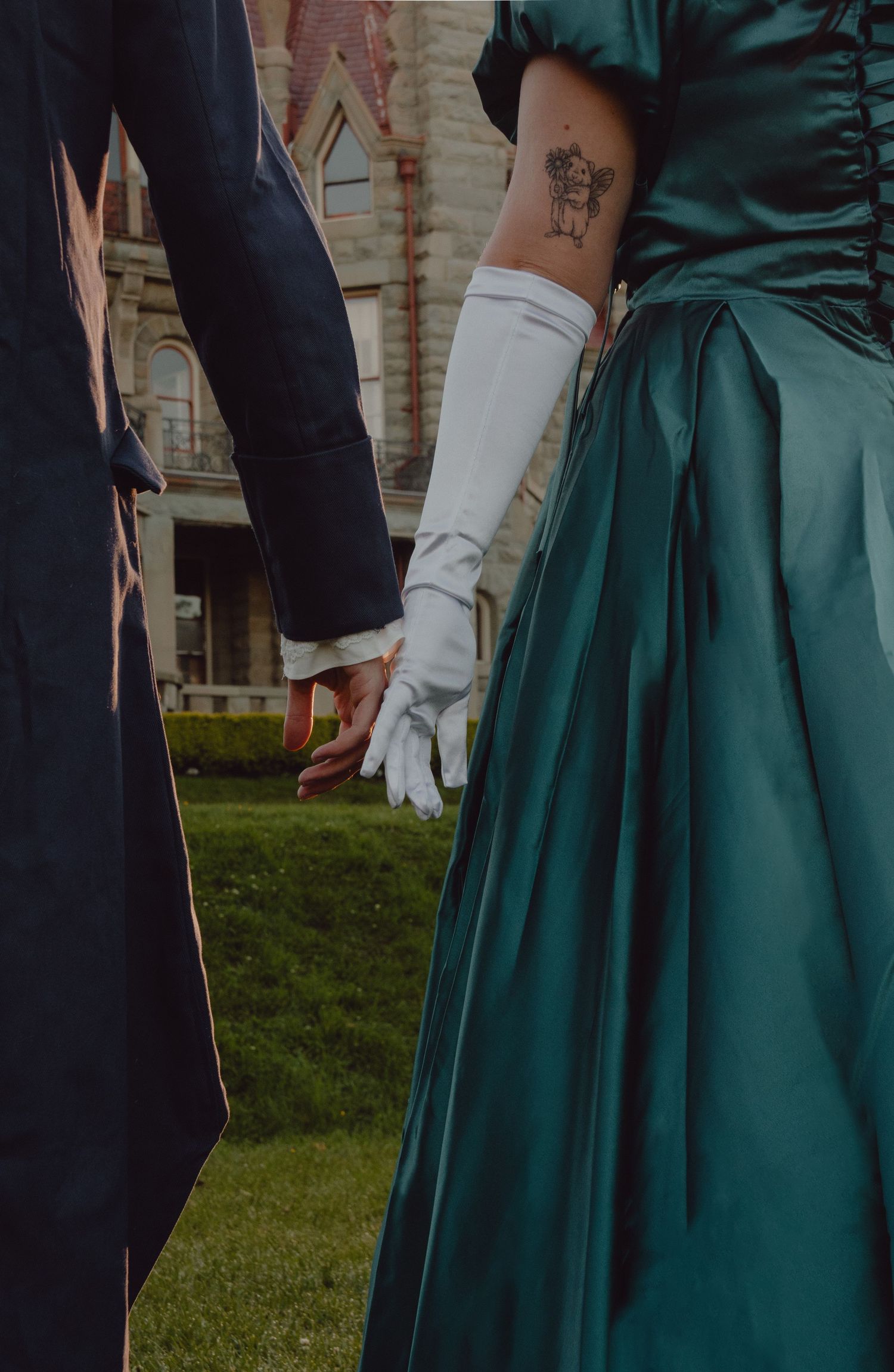 Detail shot of couple holding hands. The model is wearing long gloves to give a victorian vibe to the photo.