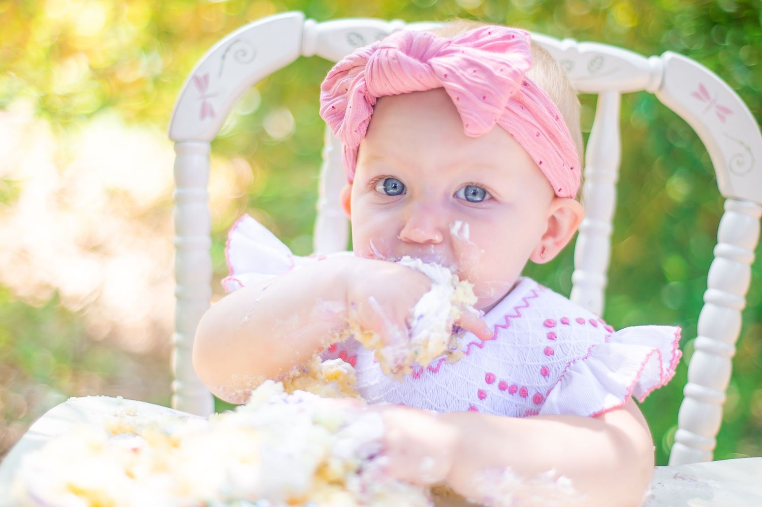 first birthday smash cake session outside wooden highchair golden hour blue eyed girl fun creative natural light Silverhill Alabama
