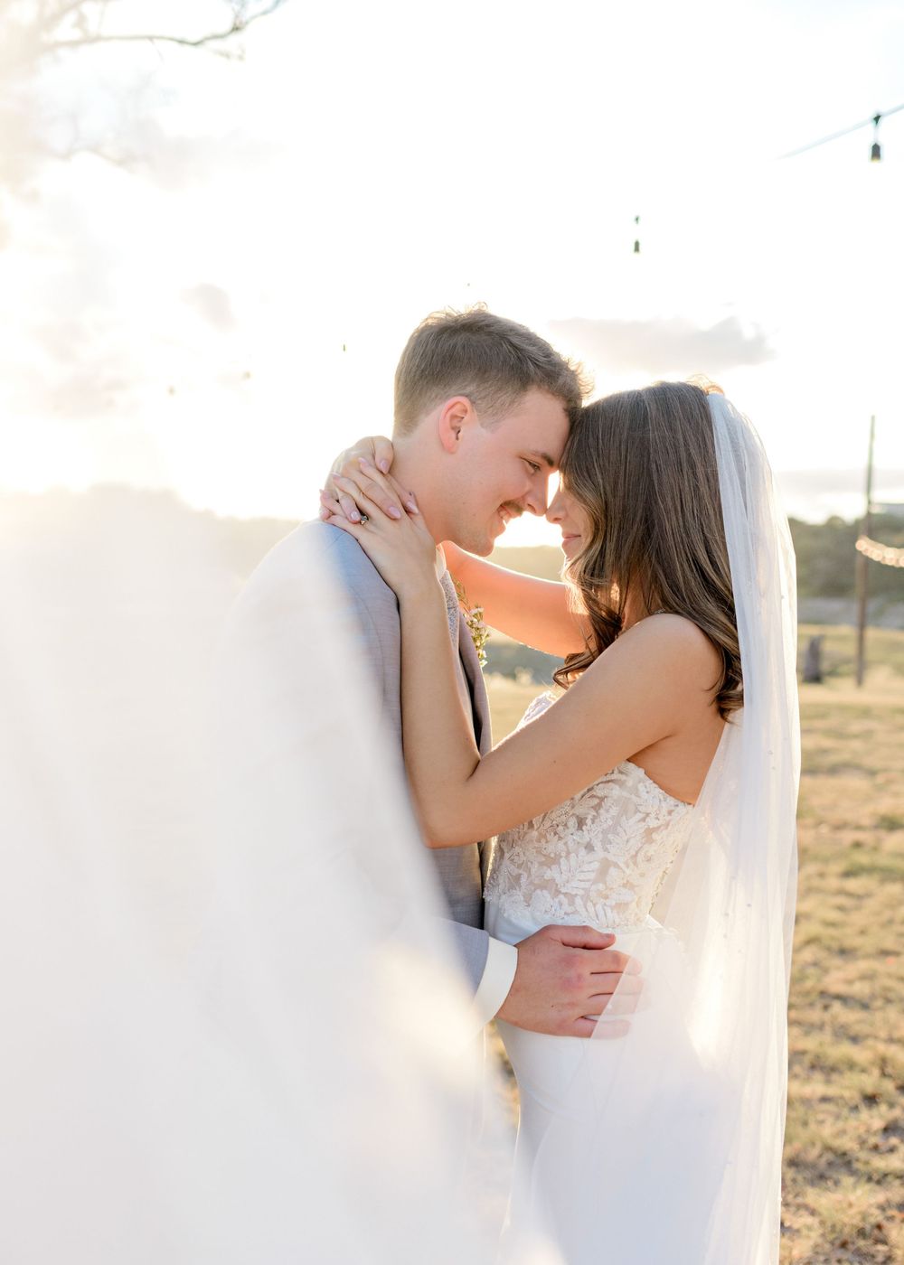 Romantic sunset wedding photo series shows couple embracing in golden light across an open field.