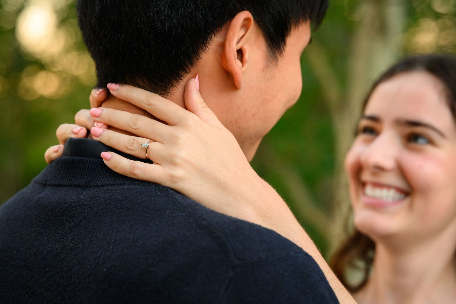 A close up shot shows a hand resting on a shoulder in an intimate moment.