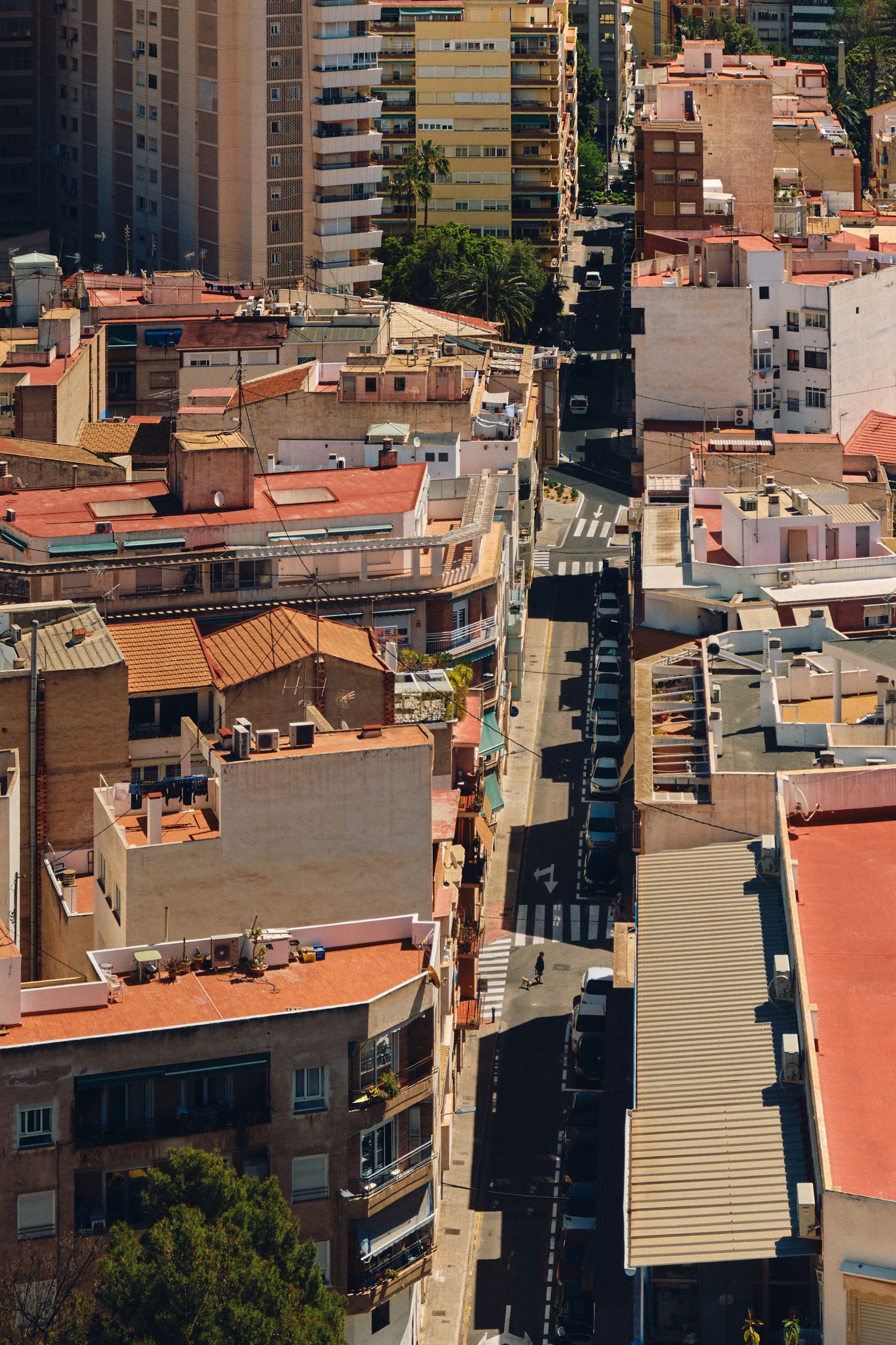 Aerial view of urban streets and terracotta rooftops in Mediterranean city.