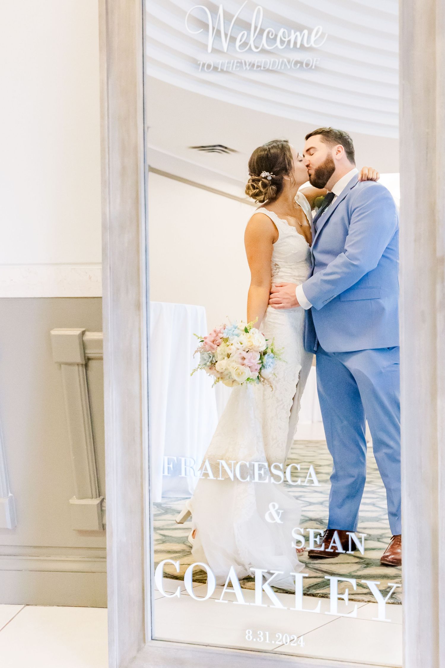 Welcome sign with text overlay featuring couple in blue suit and white dress.