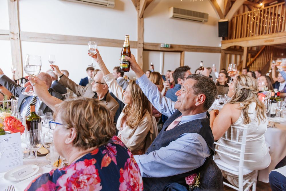 Guests are raising their glasses to toast to a couple during speeches in Cain Manor, part of Harper Weddings.