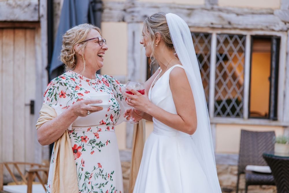 Heartfelt moment between bride and her mother during reception at Harper Weddings Cain Manor.