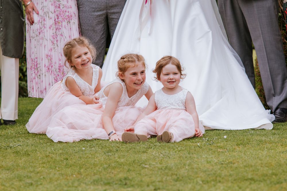 Three flower girls posing for a group photo during reception in Cain Manor which is a part of Harper Weddings.