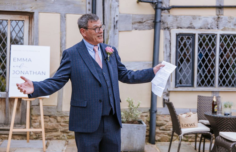 Father of the bride giving speech outdoors in Harper Weddings venue Cain Manor during a summer wedding in Hampshire.
