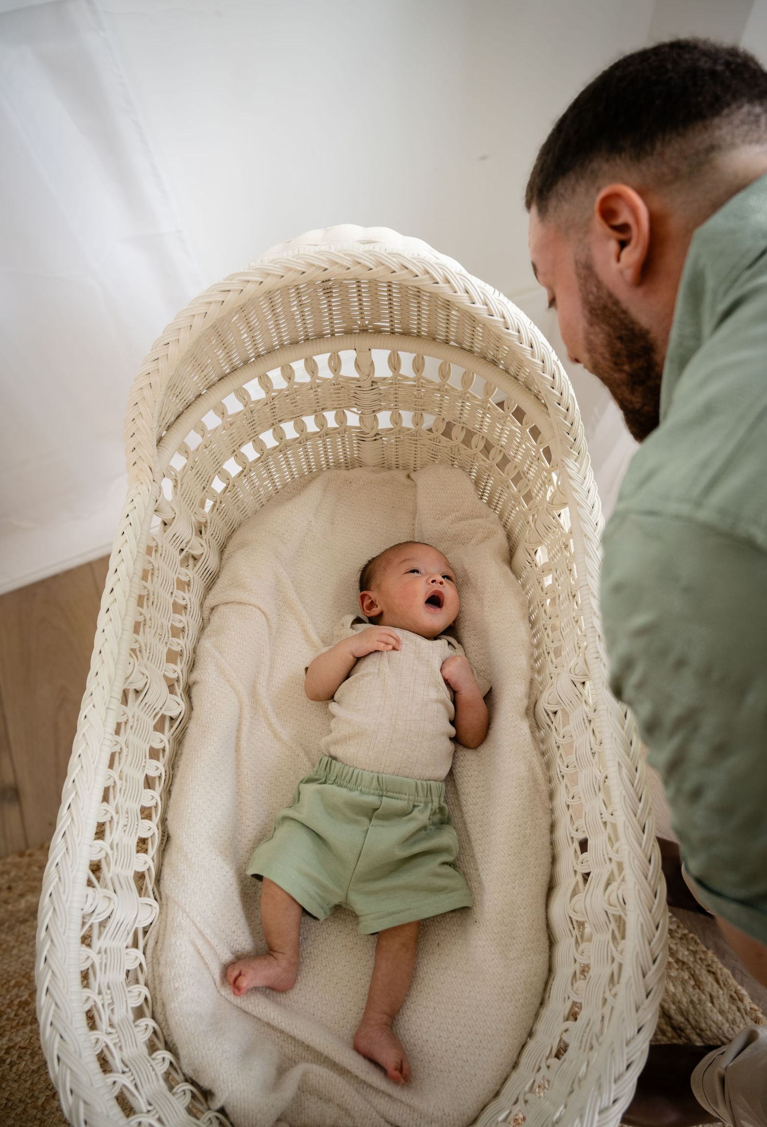 Tender moment between parent and newborn baby on cozy living room couch.