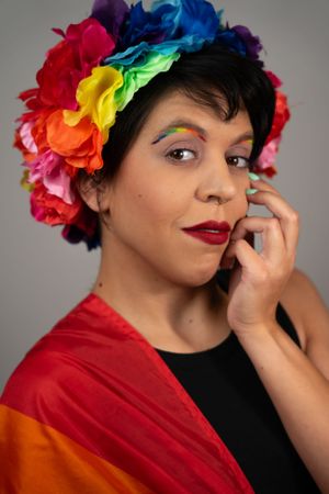 Close-up studio portraits with rainbow flower crown accessories and bold makeup.