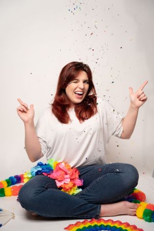 Joyful expressions surrounded by rainbow decorations and falling confetti.