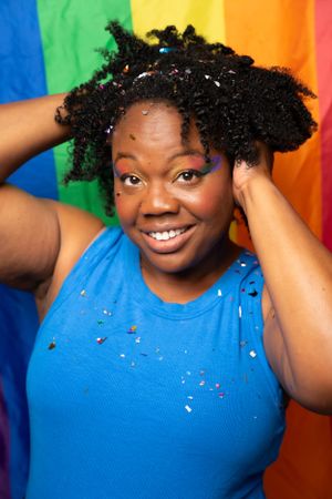 Playful portraits in front of pride flag colors showing dynamic movement and joy.