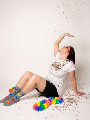 Rainbow socks and glitter sparkle in playful poses on a white backdrop.