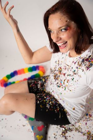 Dynamic poses with rainbow socks and scattered glitter against white background.