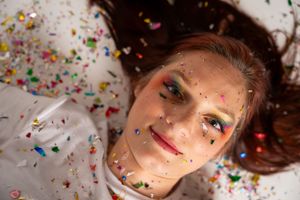 Artistic beauty shots with scattered glitter and vibrant makeup details.