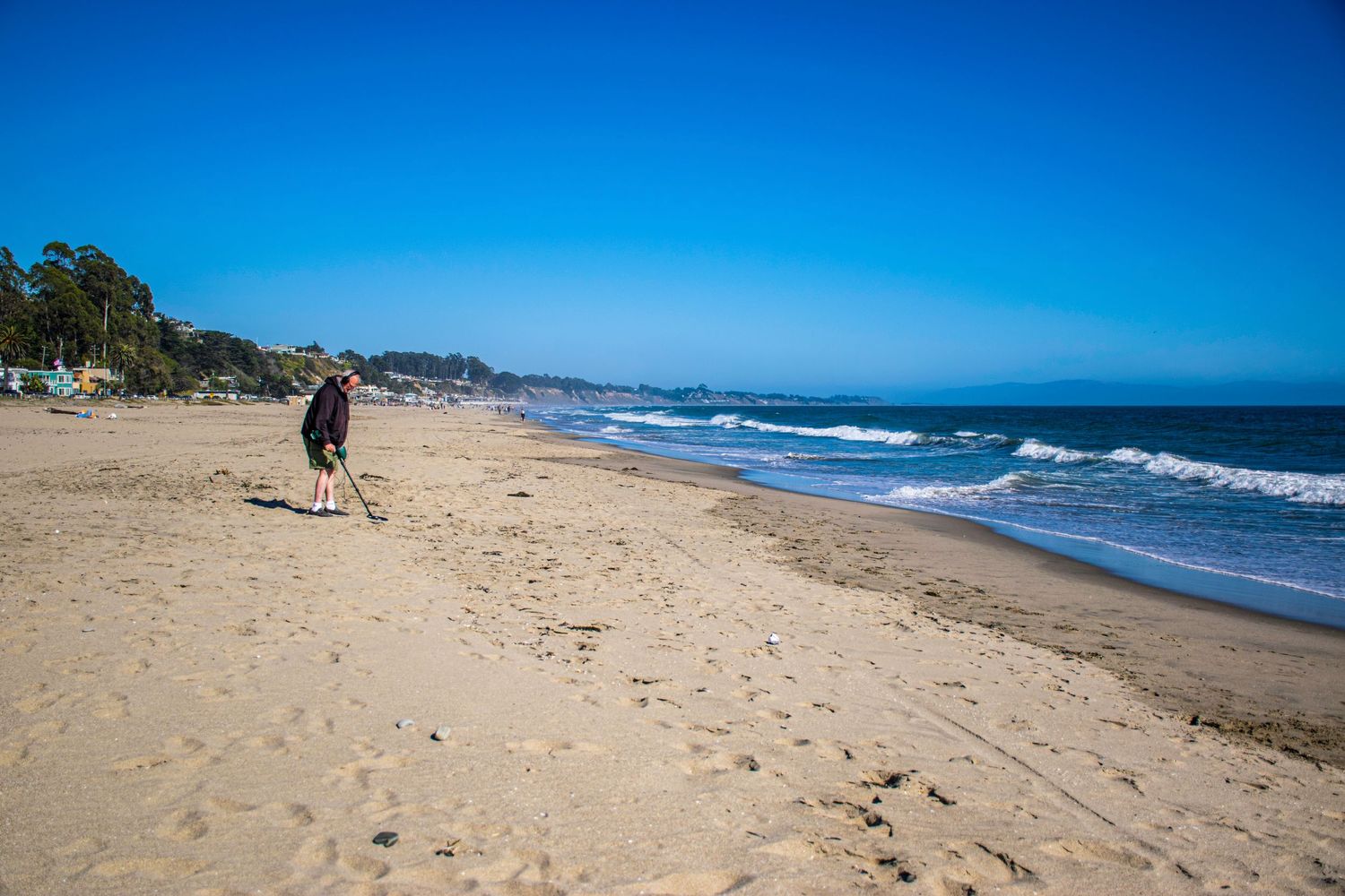 Sandy beach stretching along the Pacific coast with waves rolling in.