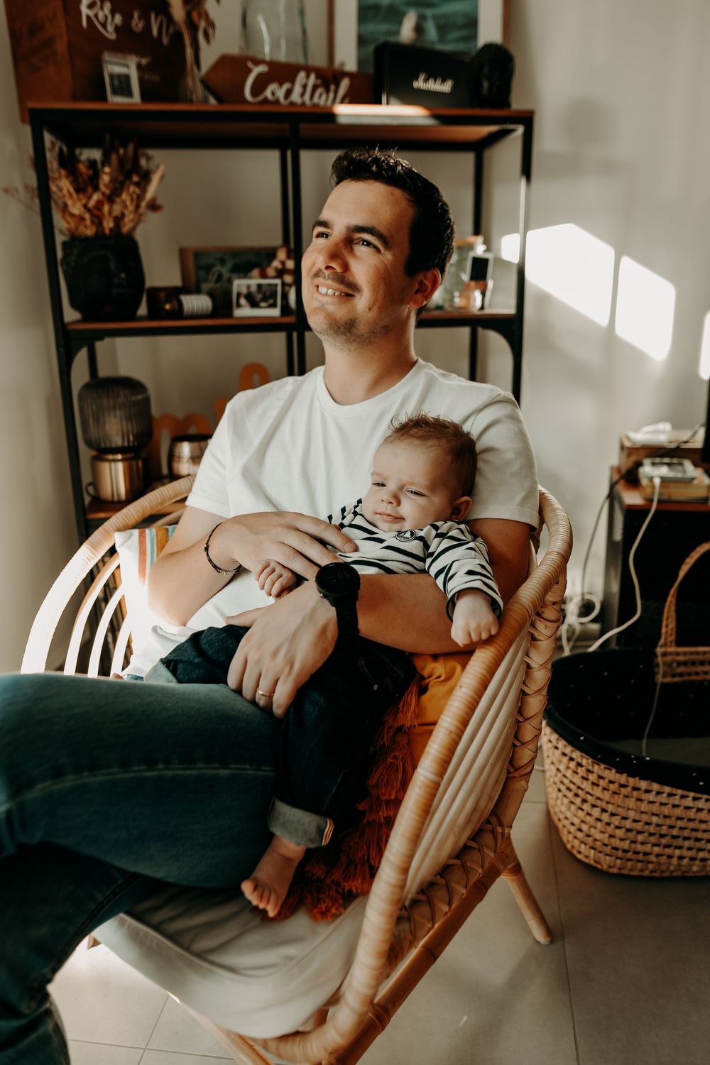 A series of candid photos showing tender moments between parent and baby relaxing on a couch in a cozy living room.