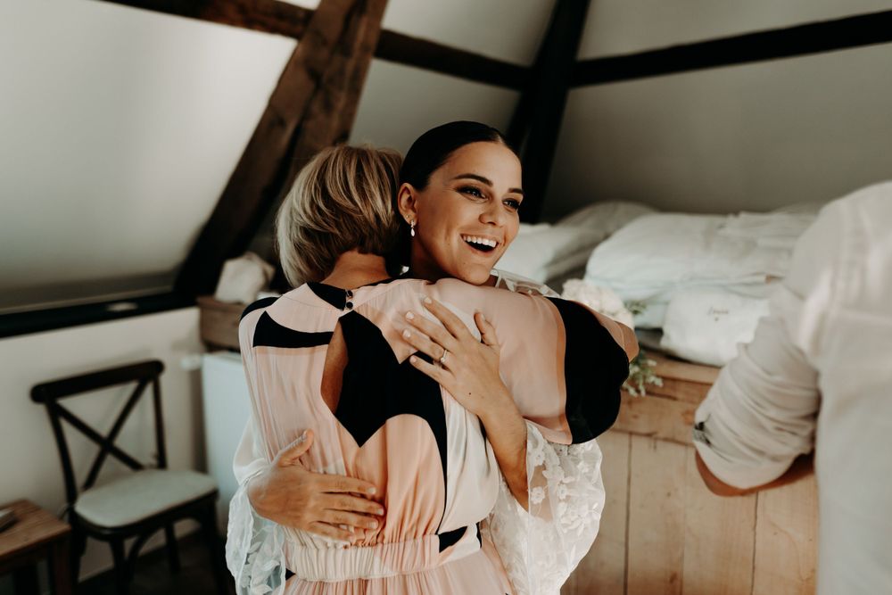 Emotional wedding moment captured in rustic venue with wooden beams.