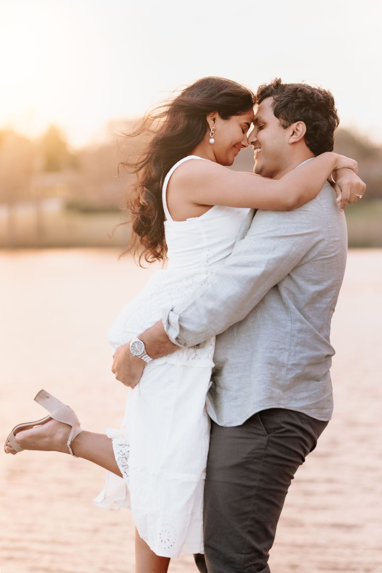A romantic couple embraces on a beach at sunset in a series of intimate poses.