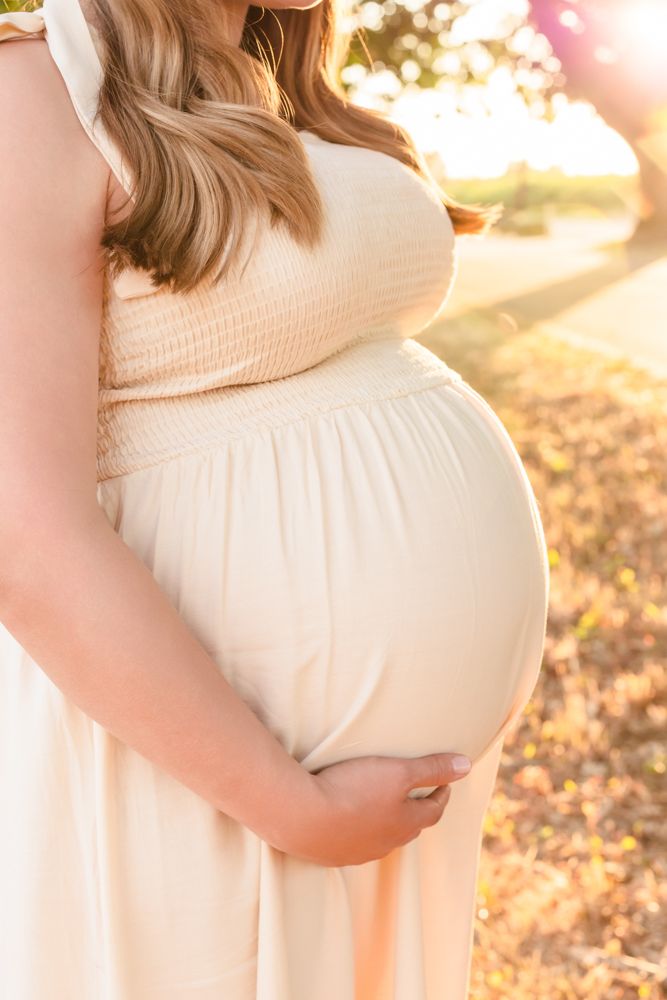 pregnant woman's belly glowing at golden hour