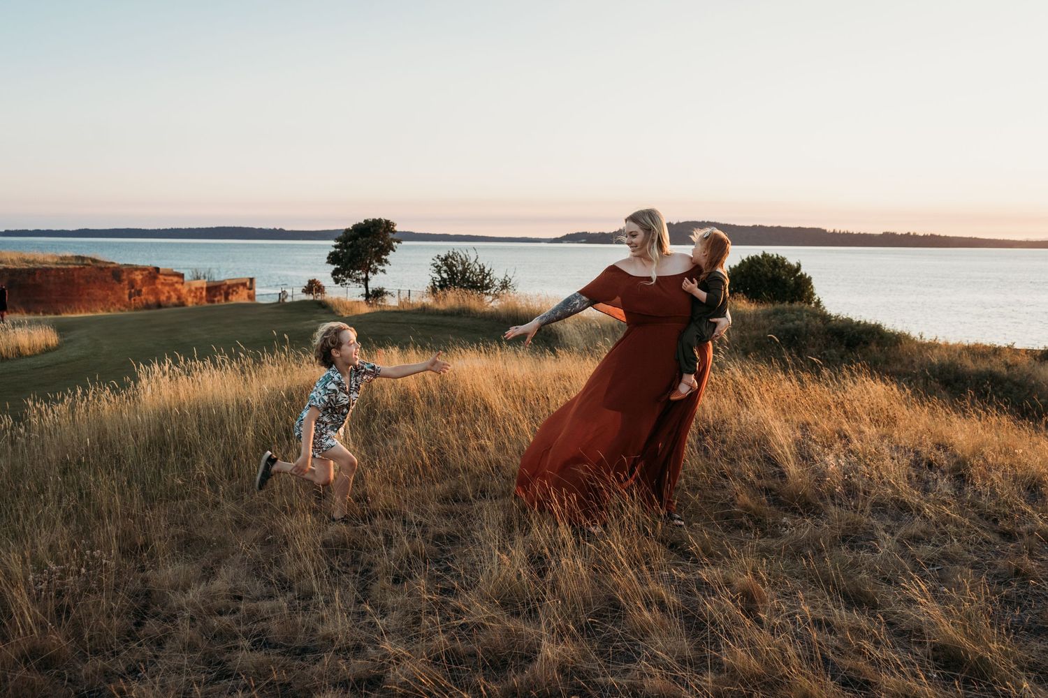 mother walking on a grassy hill with her children