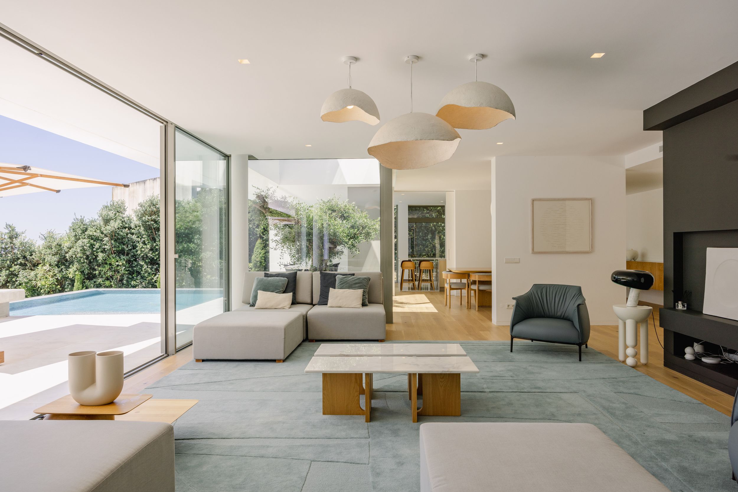 Spacious open concept living room with dome pendant lights and floor-to-ceiling windows.