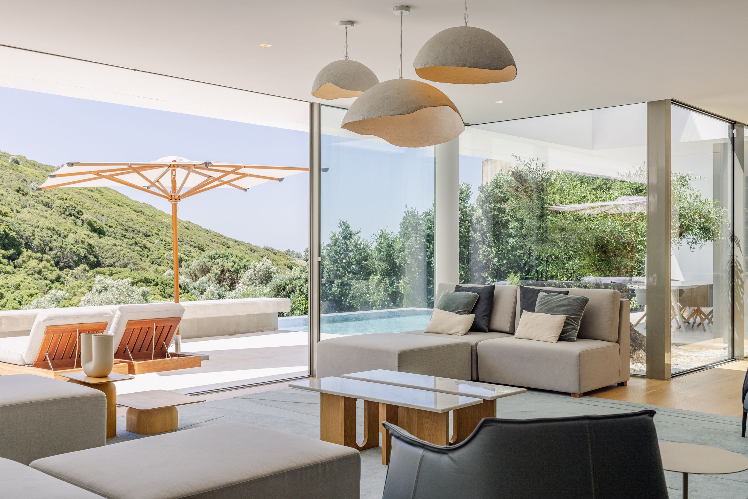 Elegant living room with panoramic views, dome pendant lights, and modern sectional sofa.