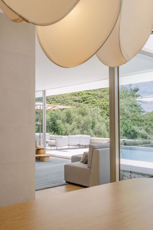 Contemporary interior space with cream pendant lights and mountain views through large windows.