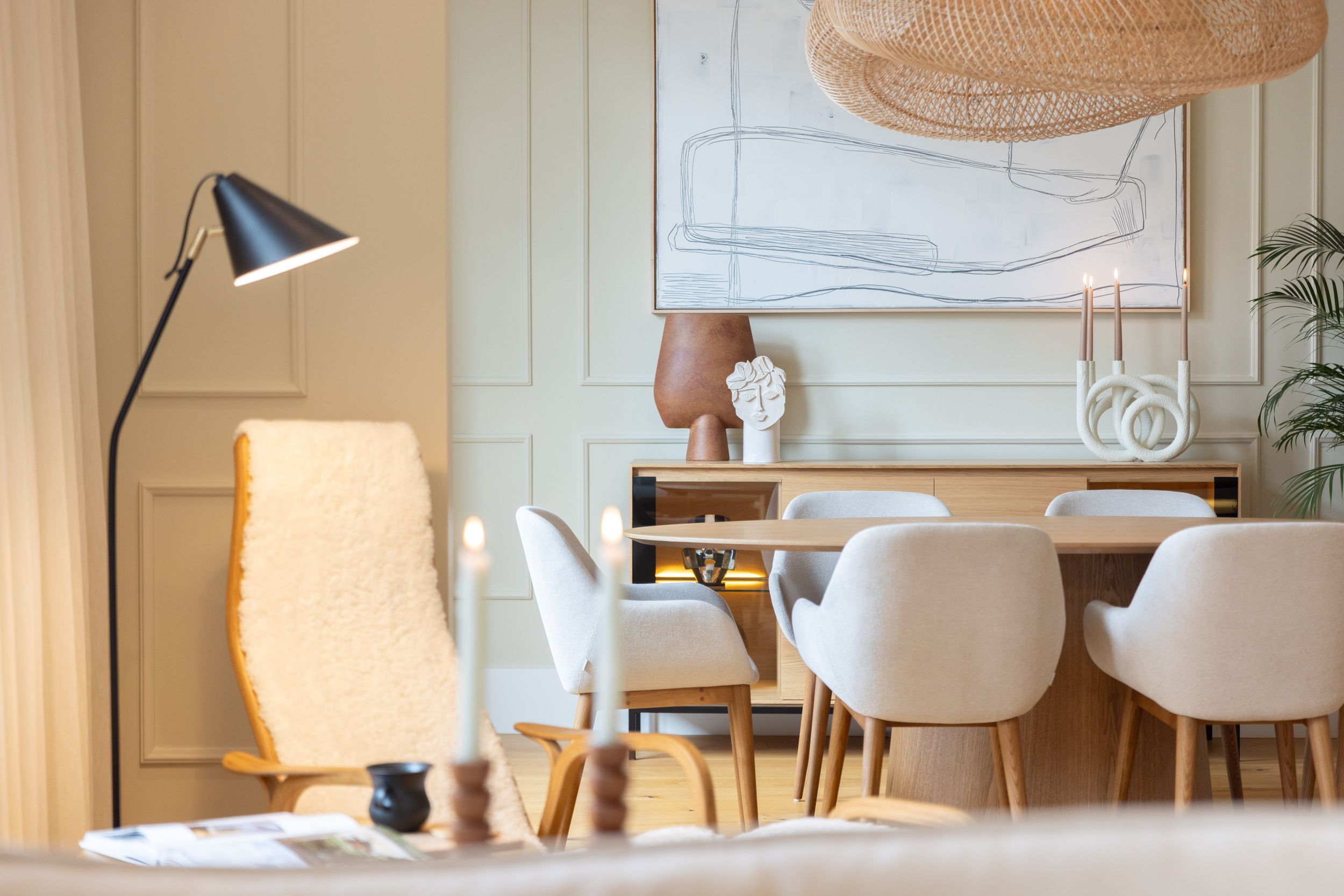 Contemporary living room corner with floor lamp, dining table and unique lighting fixture.