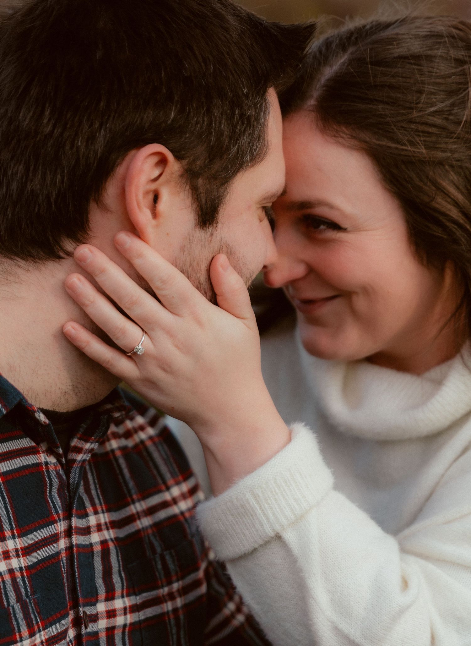 An intimate close-up moment between a couple wearing casual winter attire.