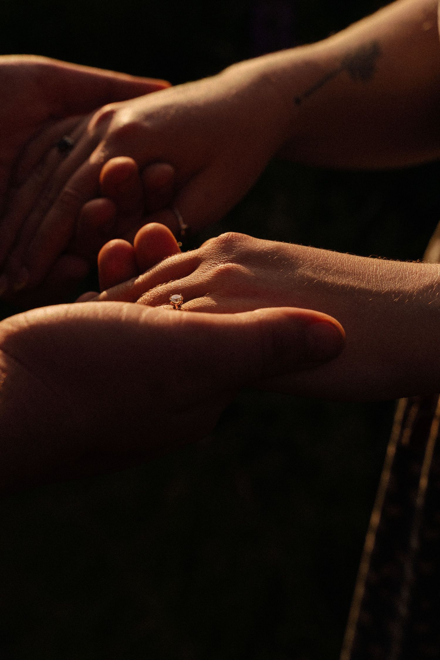 Close-up view of hands exchanging wedding rings during a romantic ceremony.
