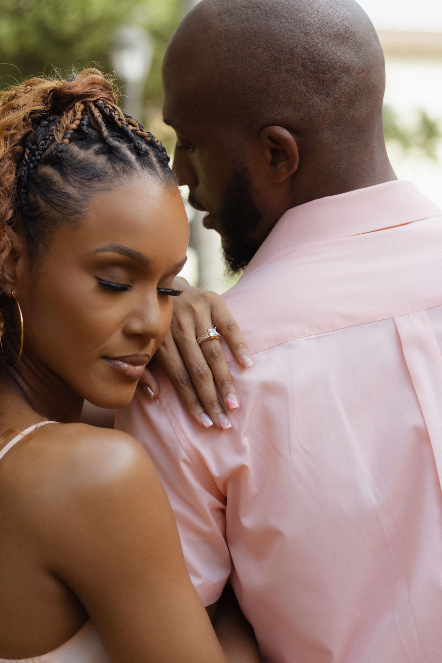 A tender moment between a couple against a light background.