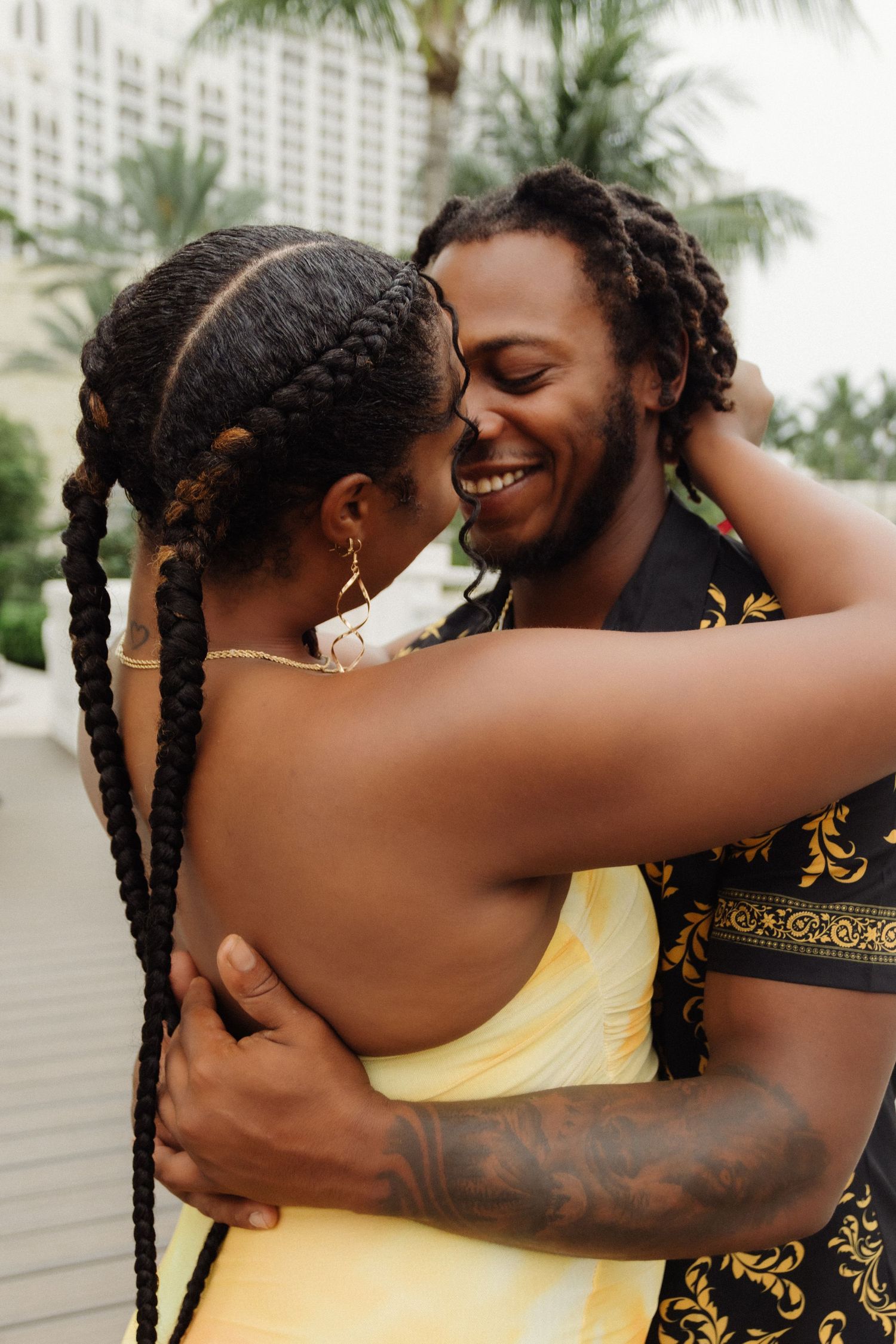 A tender embrace between a couple wearing yellow and black patterned clothing.