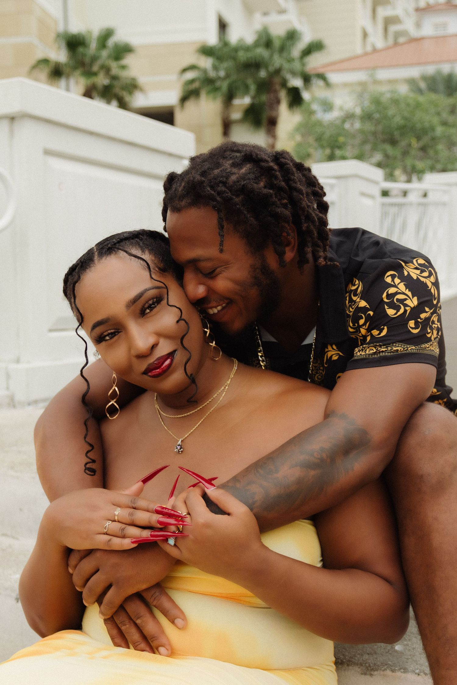 A loving couple embracing while wearing elegant black and yellow outfits.