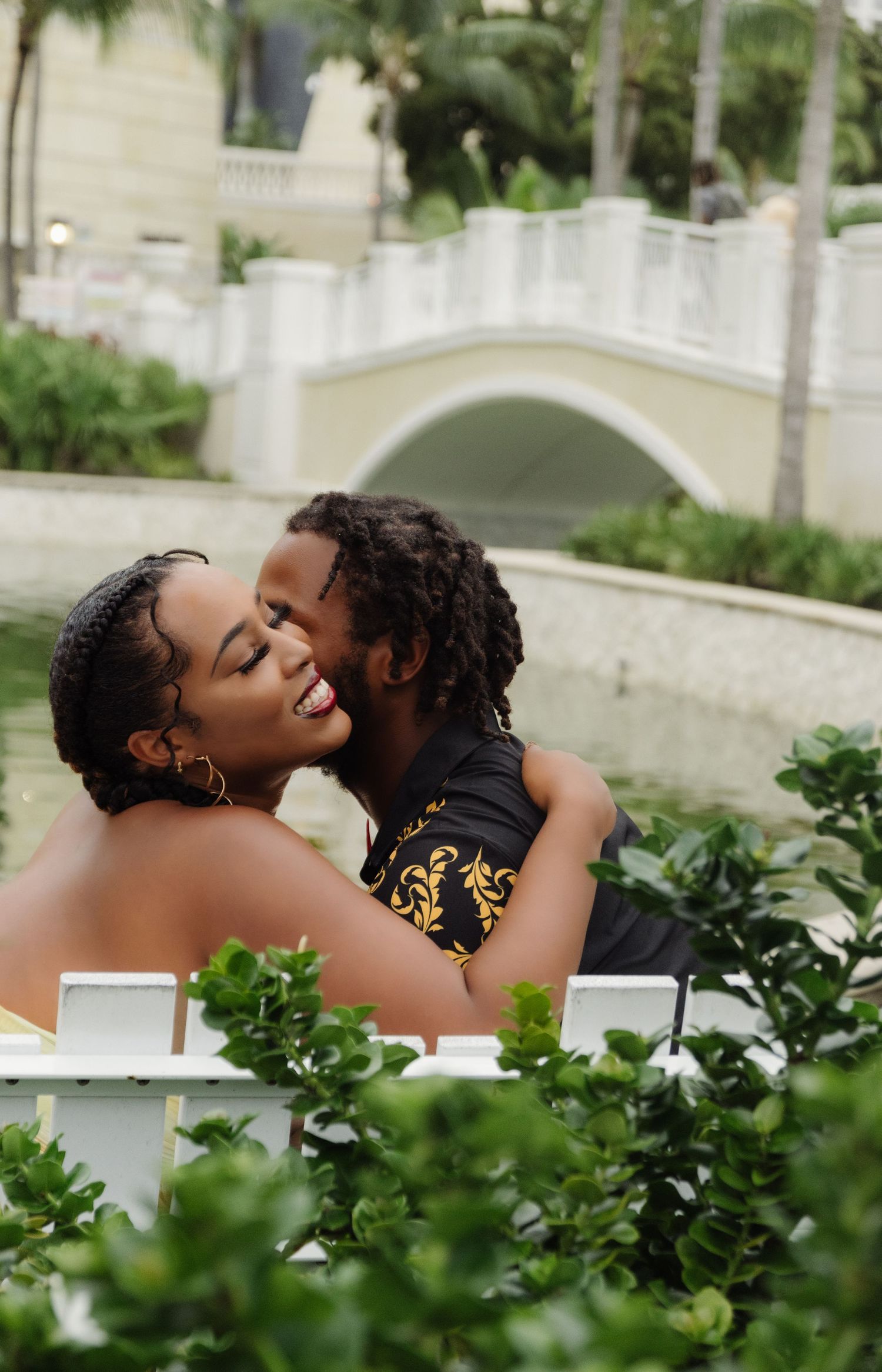 A romantic moment shared between a couple in a lush garden setting.