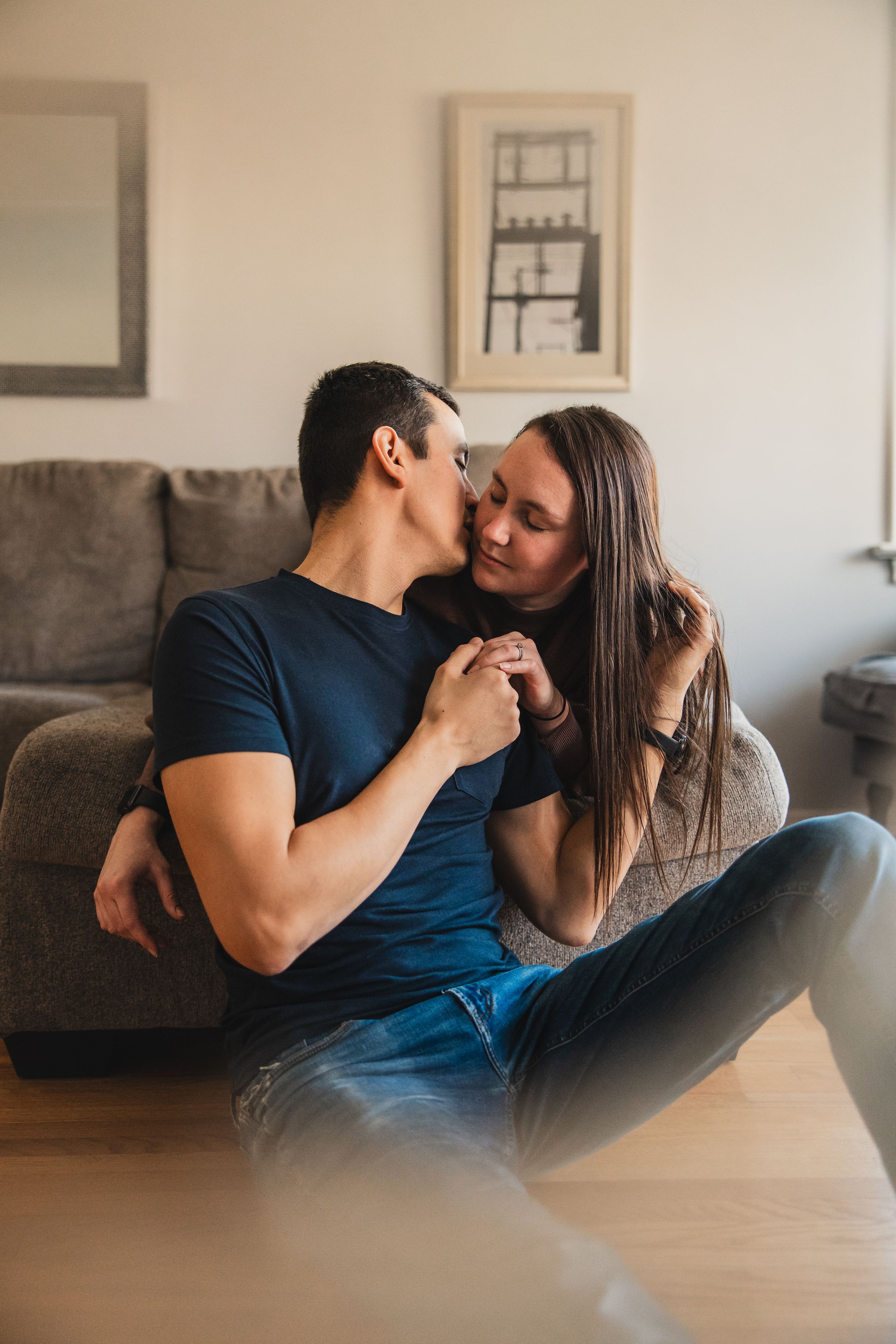 A couple shares intimate moments together on a couch in a series of candid photos showing affection and connection.